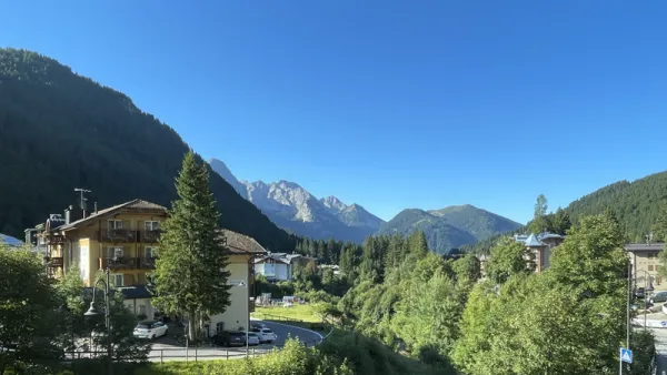 A scenic picture of the Dolomite mountains in the background against a strong blue sky